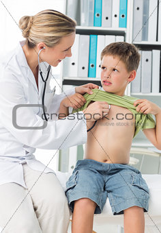 Pediatrician examining boy with stethoscope