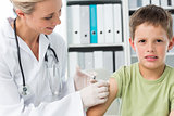 Boy receiving injection by female pediatrician