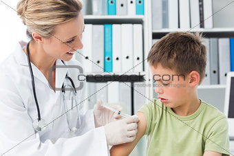 Boy receiving an injection by female doctor