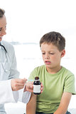 Doctor giving little boy syrup