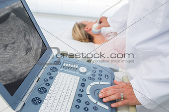 Doctor using sonogram on neck of female patient
