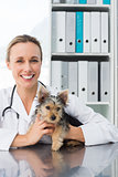 Attractive veterinarian holding dog
