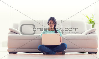 Pretty girl sitting on floor using her laptop