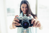 Stylish young woman taking a photo at camera
