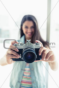 Happy young woman taking a photo at camera