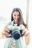 Smiling young woman taking a photo at camera