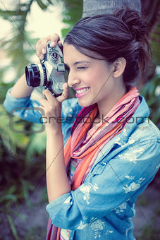 Cheerful brunette taking a photo outside
