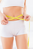 Thin woman measuring her waist