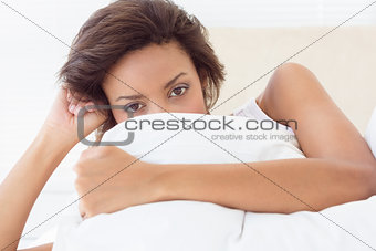 Gorgeous brunette covering face with pillow