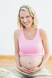 Glowing pregnant blonde smiling at camera