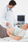 Smiling pregnant woman getting an ultrasound scan