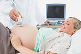 Happy pregnant woman having an ultrasound scan
