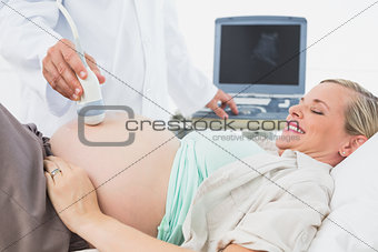 Happy pregnant woman having an ultrasound scan