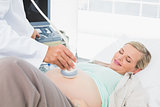 Smiling pregnant woman having a sonagram scan