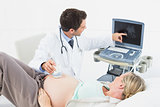 Cheerful doctor doing an ultrasound scan on pregnant woman