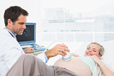 Smiling pregnant blonde woman having an ultrasound scan