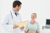 Smiling pregnant woman having a check up with doctor