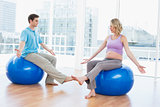 Trainer exercising with pregnant client on exercise balls
