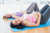 Smiling pregnant women in yoga class lying on mats