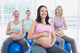 Happy pregnant women sitting on exercise balls
