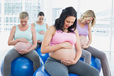 Cheerful pregnant women sitting on exercise balls