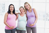 Pregnant women standing smiling at camera