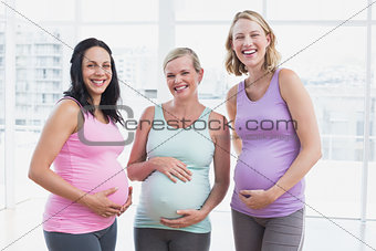 Happy pregnant women standing smiling at camera