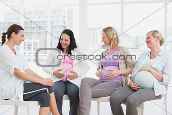 Happy pregnant women talking together at antenatal class