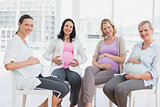Smiling pregnant women sitting together at antenatal class