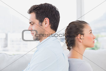 Unhappy couple sitting back to back on the couch
