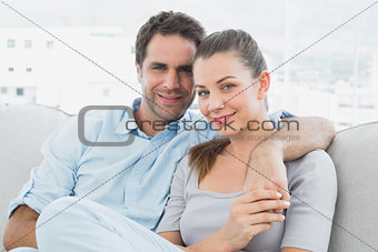 Couple sitting on the sofa smiling at camera