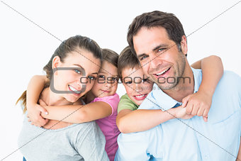 Smiling young family looking at camera together