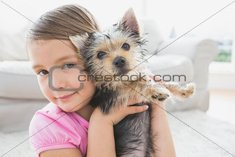 Smiling little girl holding her yorkshire terrier puppy
