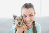 Smiling woman holding her yorkshire terrier puppy