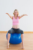Pretty pregnant woman sitting on exercise ball
