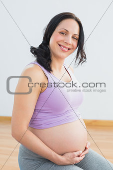 Happy pregnant brunette smiling at camera