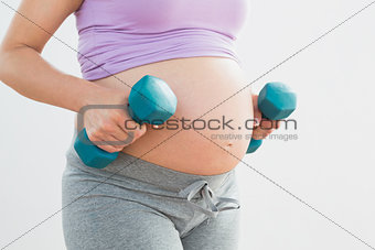 Pregnant woman holding dumbbells