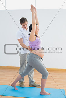 Pregnant woman doing yoga with a personal trainer