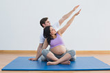 Trainer sitting with pregnant woman doing yoga