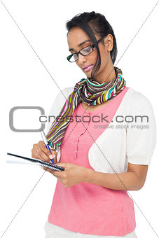 Concentrated cool woman writing in notepad