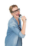Portrait of beautiful woman singing into a microphone