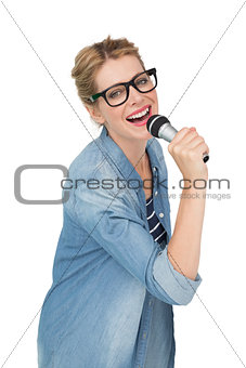 Portrait of beautiful woman singing into a microphone