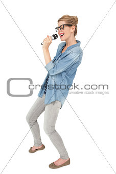 Beautiful young woman singing into a microphone