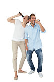 Cheerful couple singing into microphones