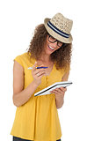 Cheerful young woman writing in notepad