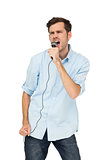 Portrait of a young man singing into microphone