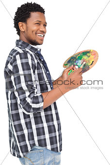 Side view of a young male painter with palette