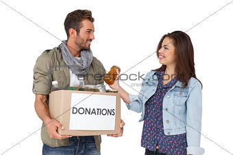 Smiling young couple with donation box