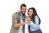 Portrait of a young couple singing into microphone