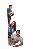 Portrait of four happy young friends with blank board